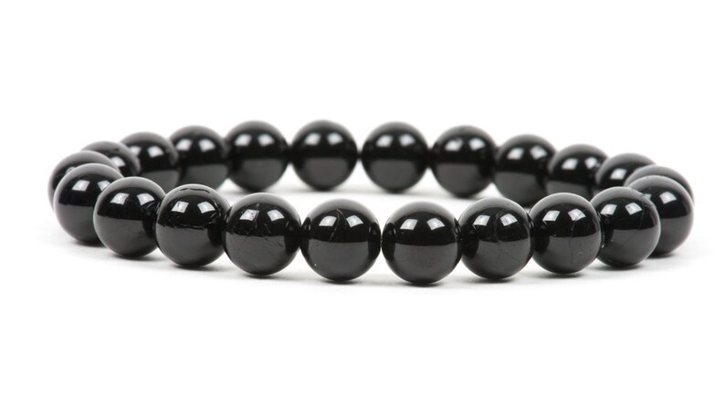 May include: A black beaded bracelet with round, smooth beads.