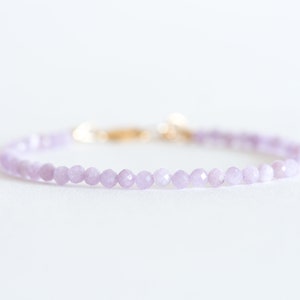 Peut inclure: Un bracelet d&eacute;licat compos&eacute; de petites perles de couleur lilas clair et d'un fermoir en or.