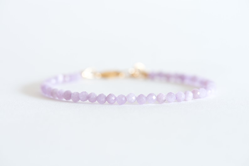 Peut inclure: Un bracelet d&eacute;licat compos&eacute; de petites perles de couleur lilas clair et d'un fermoir en or.