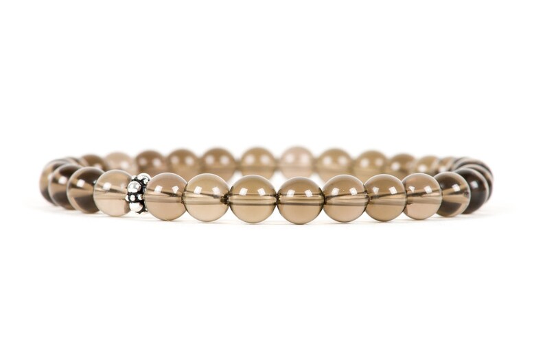 Peut inclure: Un bracelet en perles de quartz fum&eacute; brun avec un accent de perle argent&eacute;e.