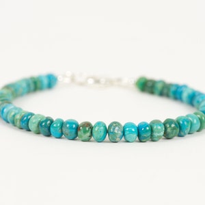 May include: A turquoise and green gemstone bracelet with a silver clasp.