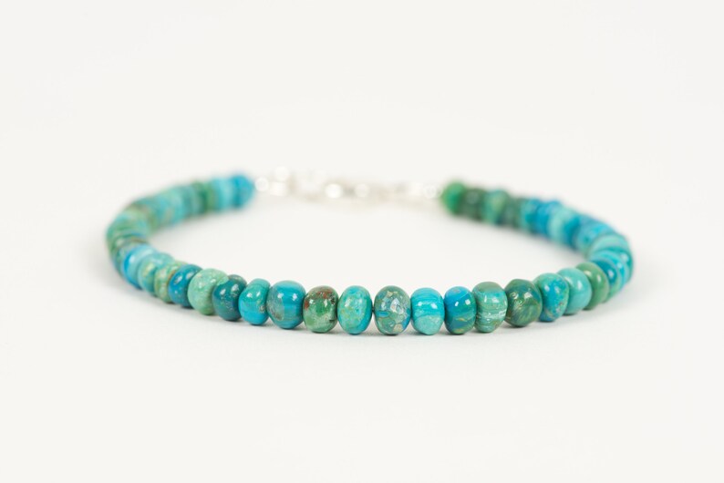May include: A turquoise and green gemstone bracelet with a silver clasp.