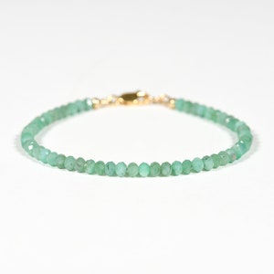 Op de afbeelding: Een delicate armband van groene edelstenen met een gouden sluiting. De armband is gemaakt van kleine, gefacetteerde kralen.