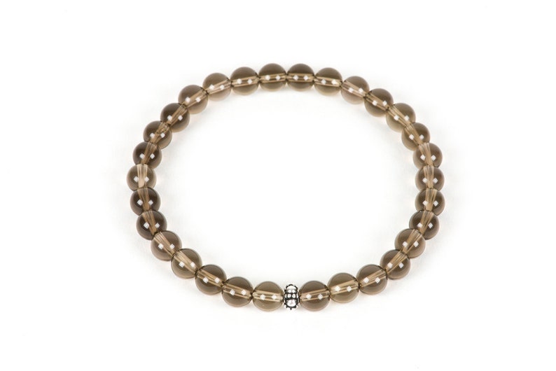 Peut inclure: Un bracelet en perles de quartz fum&eacute; brun avec un accent de perle argent&eacute;e.