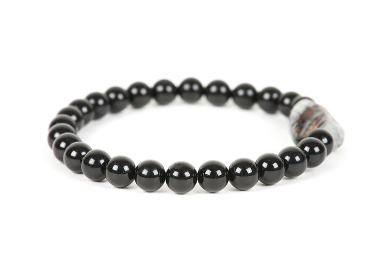 May include: A black beaded bracelet with a silver and brown bead accent.