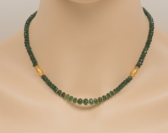 May include: A green gemstone necklace with gold accents. The necklace is made of small, faceted beads and has a simple, elegant design.