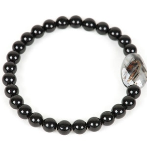 May include: Black beaded bracelet with a silver and black gemstone charm.