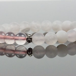Op de afbeelding: Een armband gemaakt met witte en roze edelsteen kralen en een zilveren tussenkraal.