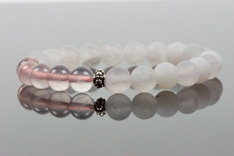 Op de afbeelding: Een armband gemaakt met witte en roze edelsteen kralen en een zilveren tussenkraal.