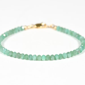 Op de afbeelding: Een delicate armband van groene edelstenen met een gouden sluiting. De armband is gemaakt van kleine, gefacetteerde kralen.