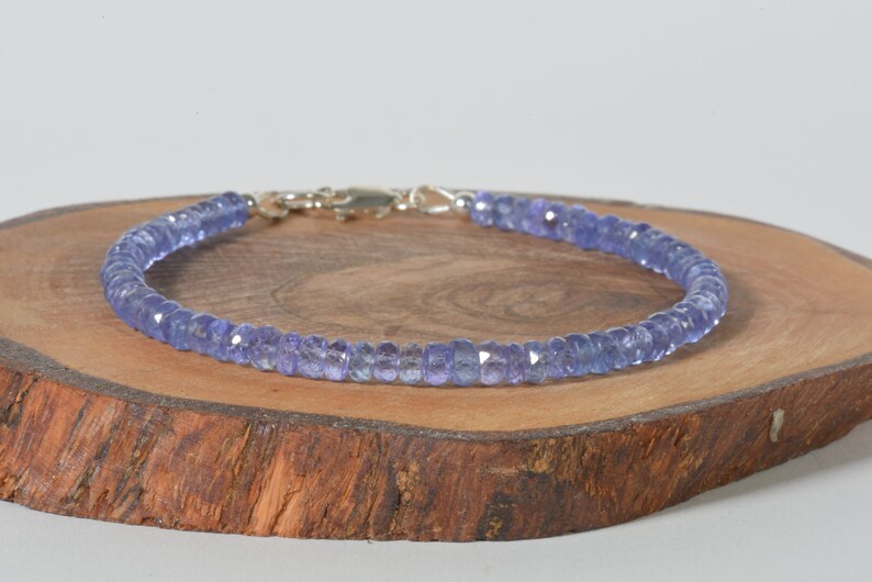 May include: A delicate bracelet made with light blue faceted gemstone beads. The bracelet has a silver clasp.