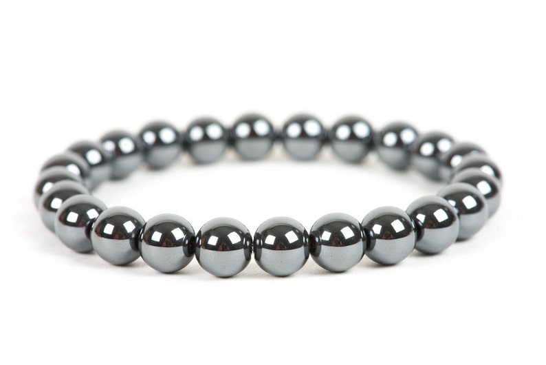 K&ouml;nnte beinhalten: Ein schwarzes H&auml;matit-Armband mit gl&auml;nzender Oberfl&auml;che.