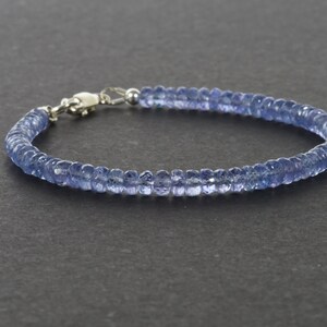 May include: A delicate blue gemstone bracelet with a silver clasp. The bracelet is made of small, round beads that are strung together to create a simple and elegant design.