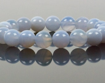 May include: A light blue gemstone bracelet with round beads. The bracelet is made of natural blue chalcedony stones.