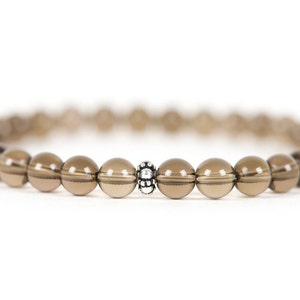 Peut inclure: Un bracelet en perles de quartz fum&eacute; brun avec un accent de perle argent&eacute;e.