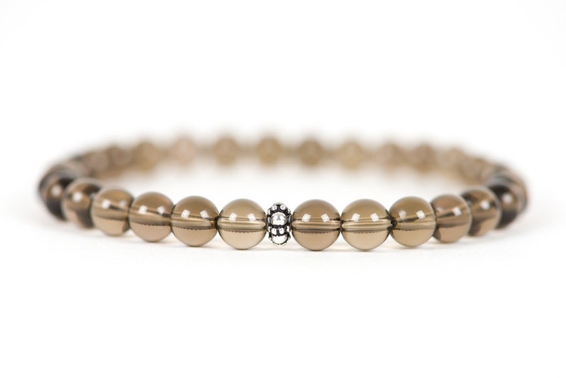 Peut inclure: Un bracelet en perles de quartz fum&eacute; brun avec un accent de perle argent&eacute;e.
