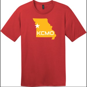 Könnte beinhalten: Rotes T-Shirt mit einer gelben Umrandung des Bundesstaates Missouri mit einem weißen Stern und dem Text "KCMO" in Weiß.
