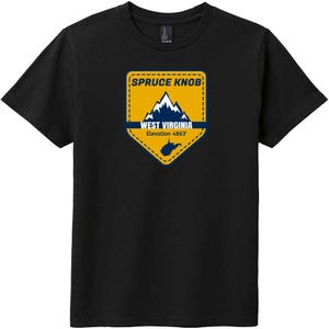 Op de afbeelding: Een zwart t-shirt met korte mouwen en een gele, schildvormige afbeelding op de borst. De afbeelding toont een bergketen, de tekst Spruce Knob, West Virginia en Elevation 4863', samen met een klein silhouet van de staat.