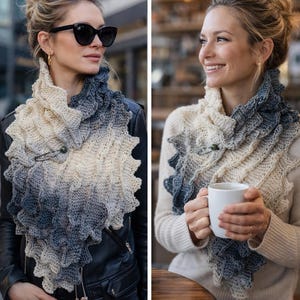 May include: A knitted scarf in a gradient of cream to grey-blue. The scarf features a ruffled edge and is fastened with a decorative pin. The scarf is worn over a black jacket and a cream sweater. The scarf is a winter accessory.