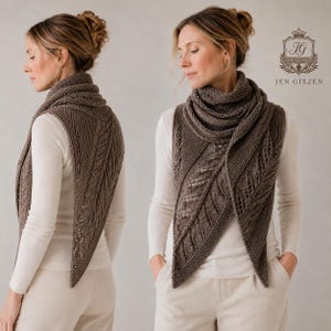 Könnte beinhalten: Ein braunes, dreieckiges Stricktuch mit einem strukturierten blattartigen Spitzenmuster und kraus rechts gestrickten Rändern. Das Tuch liegt über einem weißen Langarmshirt und einer hellen Hose. Das Logo JEN GIEZEN mit Wappen ist zu sehen.