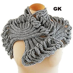 Könnte beinhalten: Ein grauer gestrickter Schal mit Rollkragen und einem einzigartigen, komplizierten Design. Der Schal ist aus weichem, leichtem Garn gefertigt und perfekt, um jedem Outfit einen Hauch von Stil zu verleihen.