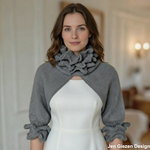 May include: A grey knitted shrug with a ruffled collar and cuffs. The bolero-style sweater has three-quarter sleeves and is worn over a white dress. The design features a textured knit pattern and a feminine silhouette. The image is signed "Jen Giezen Design."