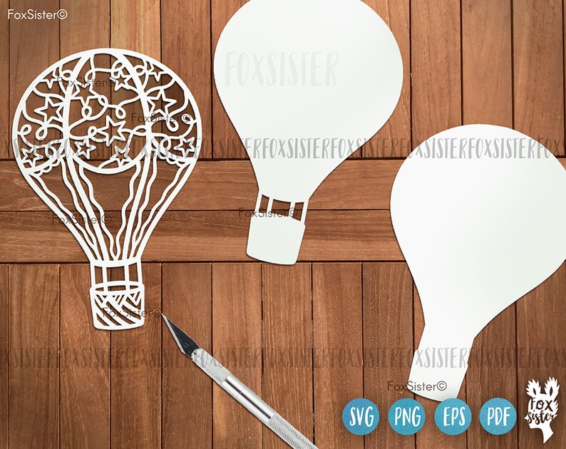 May include: Three white paper cutouts of hot air balloons. One balloon has a detailed design of stars and swirls. The other two balloons are plain. The cutouts are on a wooden surface.