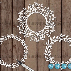 May include: Three white, decorative, paper cut-out wreaths with intricate floral designs. The wreaths are on a woodgrain background. The text "SVG PNG EPS PDF" is at the bottom of the image.