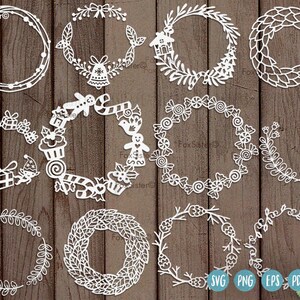 May include: A collection of white paper cut-out wreaths in various designs, including gift boxes, bells, gingerbread men, and leaves. The wreaths are arranged on a dark brown wooden surface, with SVG, PNG, EPS, and PDF icons in the lower right corner.