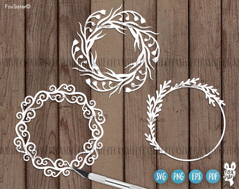 May include: Three white decorative wreaths with intricate floral designs. The wreaths are cut from paper and are perfect for crafting projects.