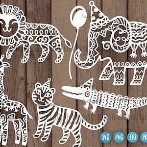 May include: A set of five white, intricate, laser-cut animal designs. The animals include a lion, giraffe, tiger, elephant, and alligator. Each animal has a party hat on its head. The designs are perfect for crafting and decorating.