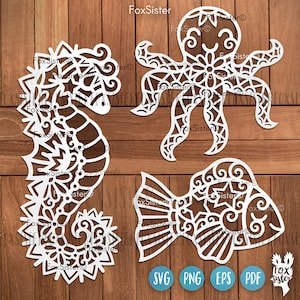 Puede incluir: Un conjunto de tres diseños blancos, intrincados y cortados con láser de un caballito de mar, un pulpo y un pez. Los diseños son perfectos para proyectos de manualidades.