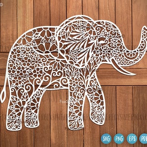 Può includere: Silhouette di elefante bianco con intricati motivi floreali e mandala. Il design è perfetto per il taglio laser, l'artigianato della carta e l'arredamento della casa.