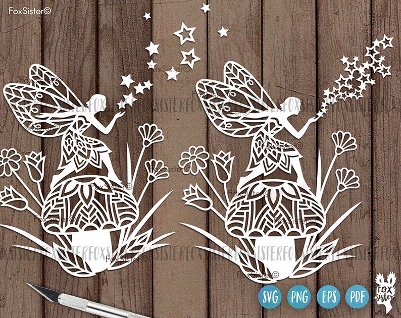 May include: Two white paper cut-out fairies blowing on stars. Each fairy is sitting on a flower with intricate mandala designs. The fairies are surrounded by flowers and stars.