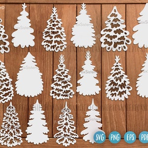 May include: A set of 12 white, cut-out Christmas tree shapes on a wood background. The trees are in various sizes and styles. The text "FoxSister" appears on the image.