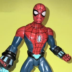 May include: A white ceramic mug with a black handle and the text "But First, Coffee" in a bold, black font. The mug is set against a blurred background, suggesting a cozy setting.