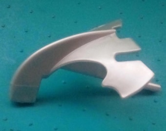 May include: White plastic part with a curved shape and a hole in the center. The part is designed to be attached to another object.