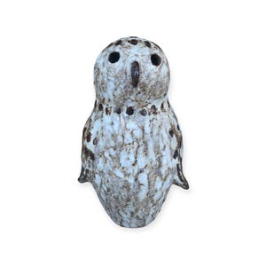 May include: A white ceramic owl figurine with brown accents and a speckled glaze. The owl has a round body and a small beak.