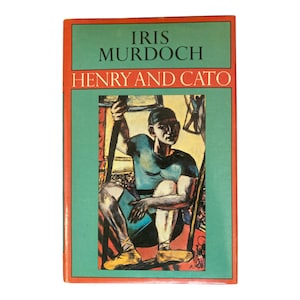 May include: A vintage paperback book titled "Henry and Cato" by Iris Murdoch. The cover features a painting of a seated figure in blue and black, holding a staff. The book has a green background with orange and red borders.