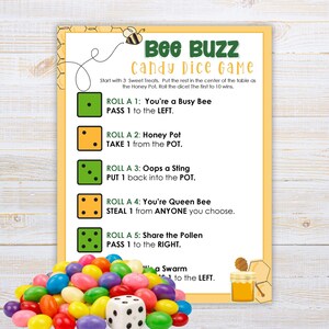 May include: A Bee Buzz candy dice game instruction card with a yellow border, bee graphics, and text detailing rules for rolling dice. A pile of colorful jelly bean candies and a single white six-sided die with black pips sit in the foreground.