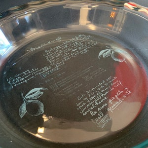 May include: A clear glass pie plate with a handwritten recipe for meringue on the inside. The recipe includes ingredients like egg whites, sugar, and lemon juice. The recipe also includes instructions for baking the meringue at 250 degrees Fahrenheit for 40 minutes.