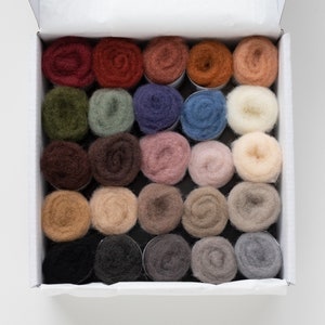 May include: A box filled with 24 small rolls of wool yarn in various colors, including shades of brown, blue, green, pink, and white.