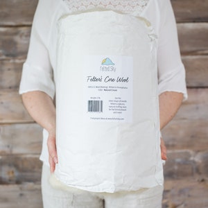 May include: A white bag of Felted Sky Felter's Core Wool, 100% US Wool, Natural Cream, 2 lb.  The bag has a label with the company logo and information about the product.  Find project ideas at www.feltedsky.com.