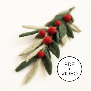 May include: A handcrafted felted sprig with green and gray leaves and vibrant red berries. The design features a natural, organic aesthetic, perfect for seasonal decor or crafting projects. The image includes a circular graphic with the text "PDF + VIDEO".