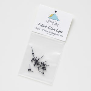 May include: A clear plastic bag containing 10 pairs of 4 mm black glass eyes on wire. The bag has a white label that says "Felted Sky" and "Felter's Glass Eyes".