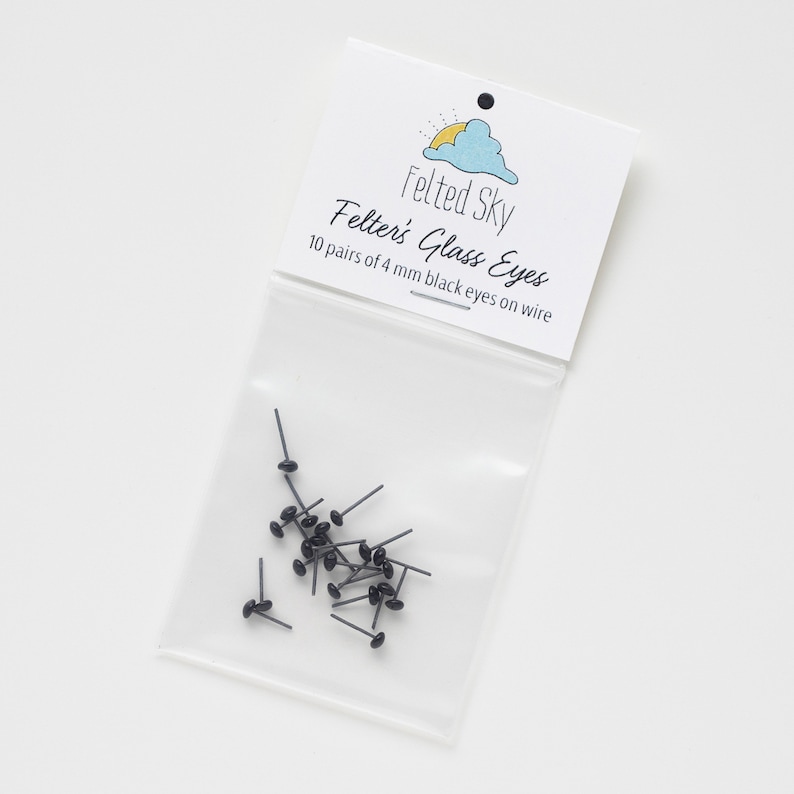 May include: A clear plastic bag containing 10 pairs of 4 mm black glass eyes on wire. The bag has a white label that says "Felted Sky" and "Felter's Glass Eyes".