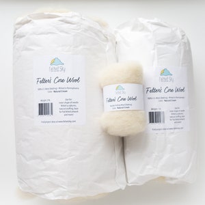 May include: Two packages of Felted Sky Felter's Core Wool in Natural Cream color. The larger package is 3 lb and the smaller package is 1 lb. The packages are made of white paper with a label that says "Felted Sky Felter's Core Wool 100% U.S. Wool Batting. Milled in Pennsylvania. Color: Natural Cream. Weight: 3 lb. Use for inner shape of needle felted sculptures, natural felting, base for flat felted artwork and more! Find project ideas at www.feltedsky.com"