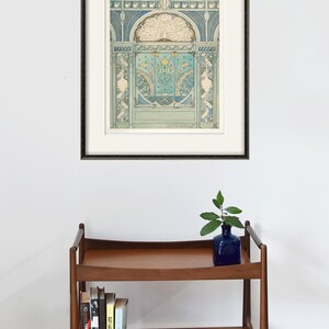 Peut inclure: Une estampe encadr&eacute;e d'une illustration vintage repr&eacute;sentant un motif de paon dans des tons de bleu, vert et blanc. L'illustration est plac&eacute;e sur un fond d'arche d&eacute;corative avec des d&eacute;tails complexes.