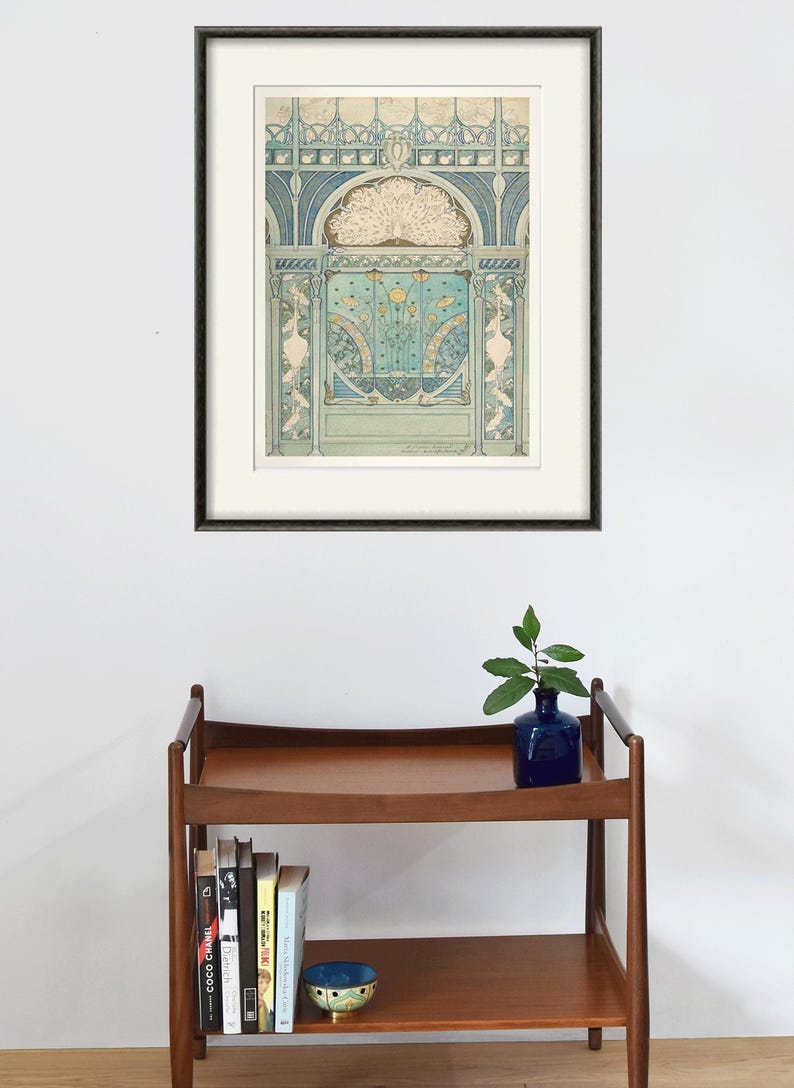 Peut inclure: Une estampe encadr&eacute;e d'une illustration vintage repr&eacute;sentant un motif de paon dans des tons de bleu, vert et blanc. L'illustration est plac&eacute;e sur un fond d'arche d&eacute;corative avec des d&eacute;tails complexes.