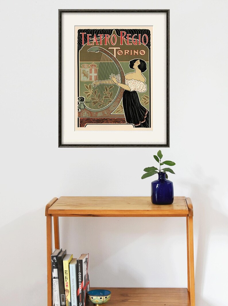 Peut inclure: Une affiche vintage pour le Teatro Regio de Turin, en Italie. L'affiche repr&eacute;sente une femme jouant du harpe sur un fond floral d&eacute;coratif. Le texte sur l'affiche est "Teatro Regio Torino".
